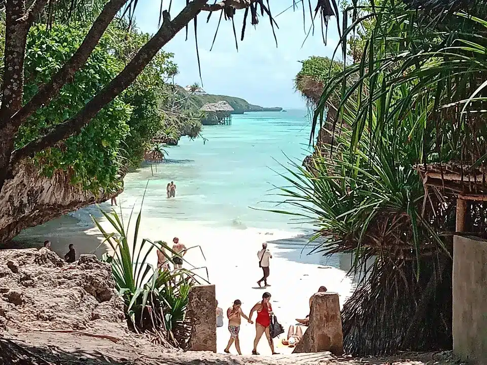 Petite crique secrète à Zanzibar bordée de falaises, sable blanc et lagon turquoise